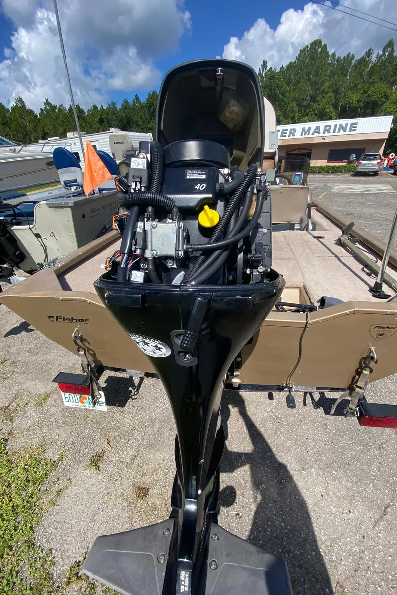 Slide: The Image of 2006 Fisher 1600 boat with outboard motor in a marine dealership lot. - 8