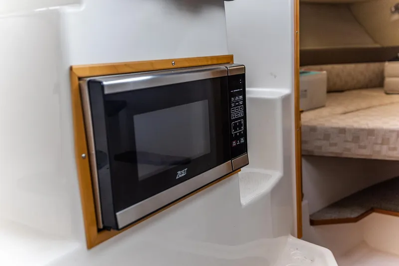 Slide: The Image of 2023 Cutwater C-248 Coupe interior with built-in microwave and cozy cabin space. - 10