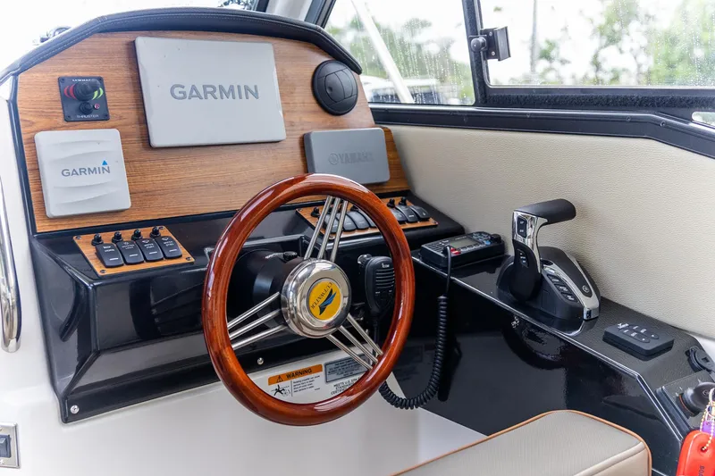 Slide: The Image of 2023 Cutwater C-248 Coupe helm with Garmin navigation and wooden steering wheel. - 12