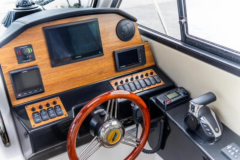 Slide: The Image of 2023 Cutwater C-248 Coupe helm with wood accents, steering wheel, and navigation controls. - 13