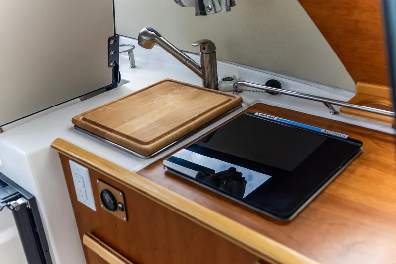 Slide: The Image of 2023 Cutwater C-248 Coupe kitchen area with cutting board and stove. - 14