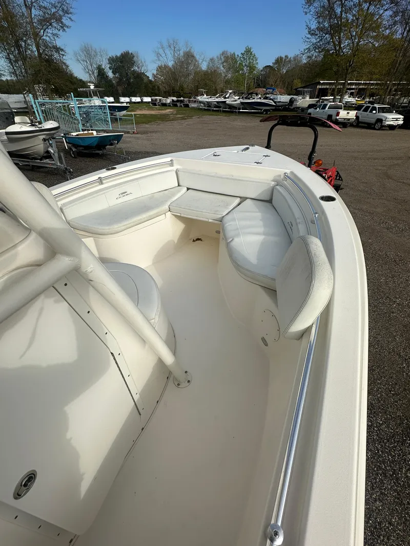 Slide: The Image of 2022 Cobia 220 Center Console boat with spacious seating, parked outdoors. - 11