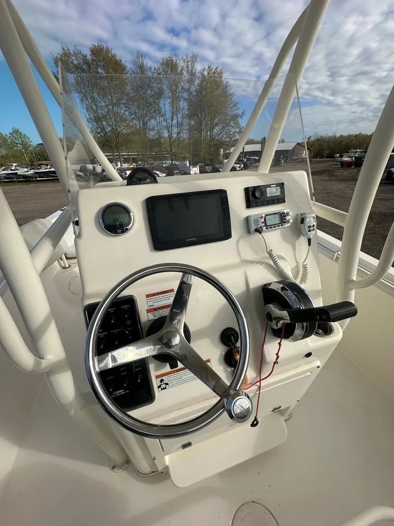 Slide: The Image of 2022 Cobia 220 Center Console boat dashboard with steering wheel and navigation equipment. - 17