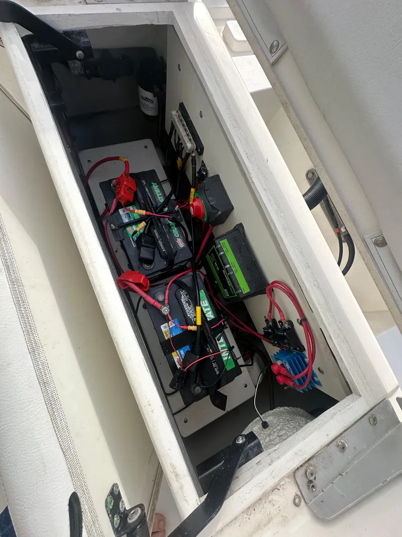 Slide: The Image of Battery compartment of 2022 Cobia 220 Center Console boat with wiring and components. - 19