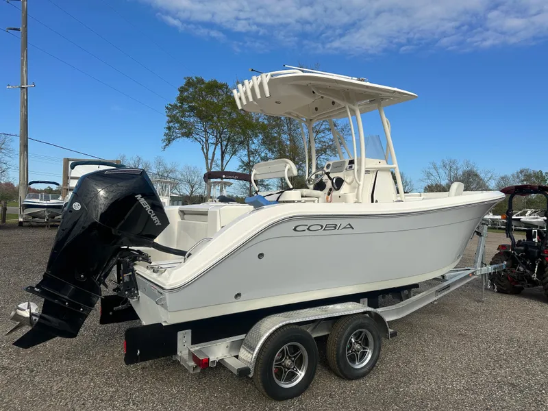 Slide: The Image of 2022 Cobia 220 Center Console boat on trailer, parked outdoors. - 2