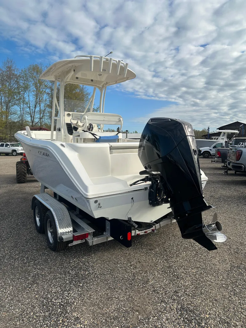 Slide: The Image of 2022 Cobia 220 Center Console boat on trailer, featuring powerful outboard motor. - 3
