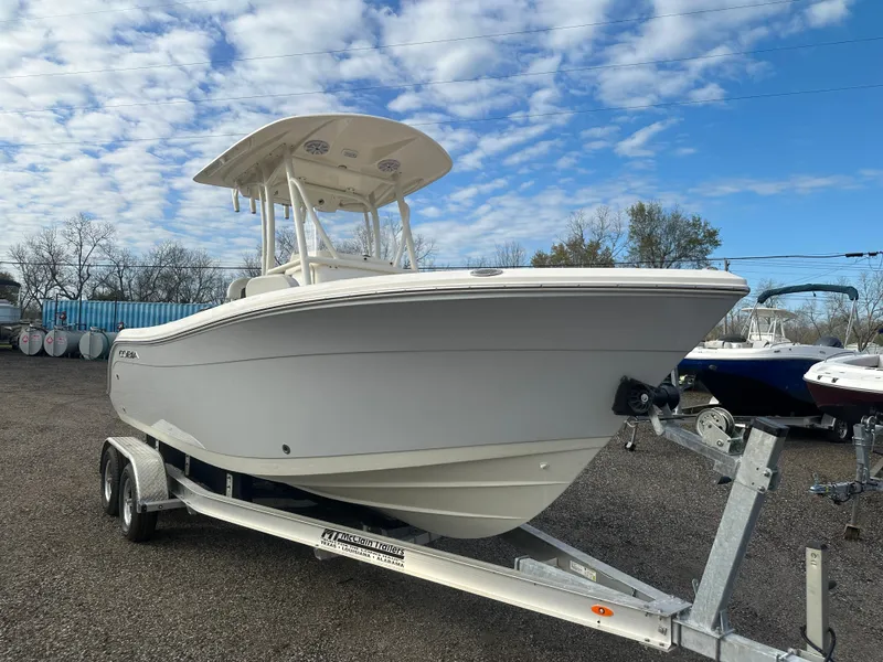 Slide: The Image of 2022 Cobia 220 Center Console boat on trailer under a partly cloudy sky. - 6