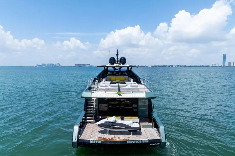 Slide: The Image of Luxurious 2023 Wally WHY 150 yacht cruising near a city skyline on a sunny day. - 1