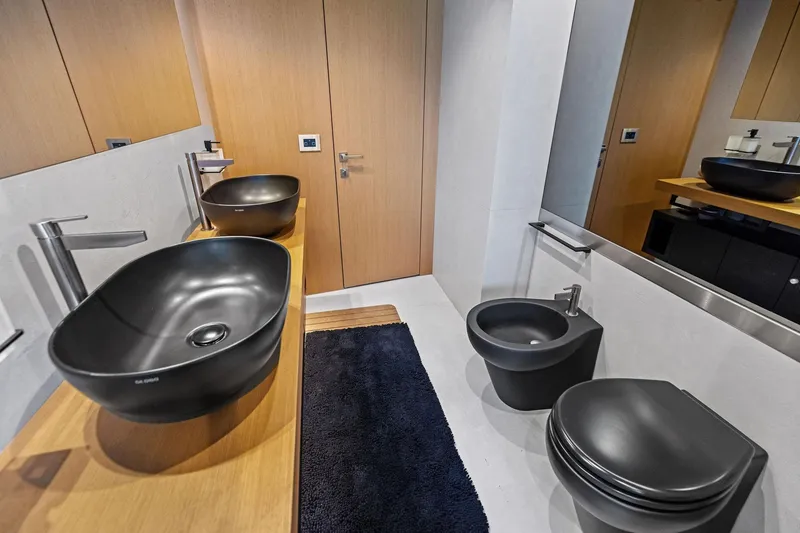 Slide: The Image of Modern bathroom with black fixtures, wooden accents, and sleek design in a 2023 Wally WHY 150. - 103