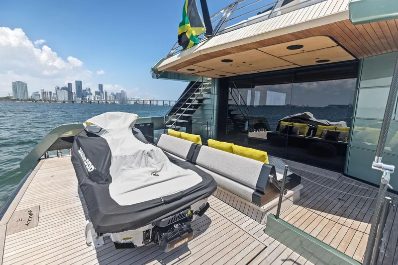 Slide: The Image of Luxurious 2023 Wally WHY 150 yacht deck with city skyline view, featuring modern seating and jet ski. - 23