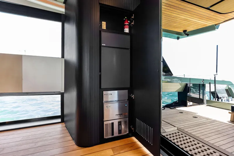 Slide: The Image of Modern yacht interior with open cabinet, featuring appliances and a fire extinguisher, aboard 2023 Wally WHY 150. - 27