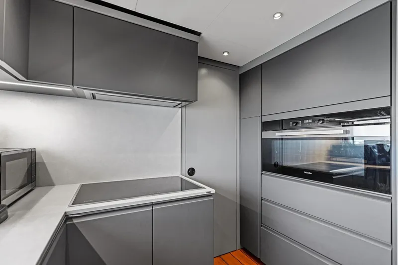Slide: The Image of Modern kitchen interior in 2023 Wally WHY 150 yacht, featuring sleek gray cabinetry and appliances. - 60