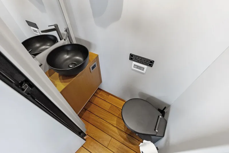 Slide: The Image of Modern yacht bathroom with black sink, wooden flooring, and compact toilet in Wally WHY 150, 2023. - 87