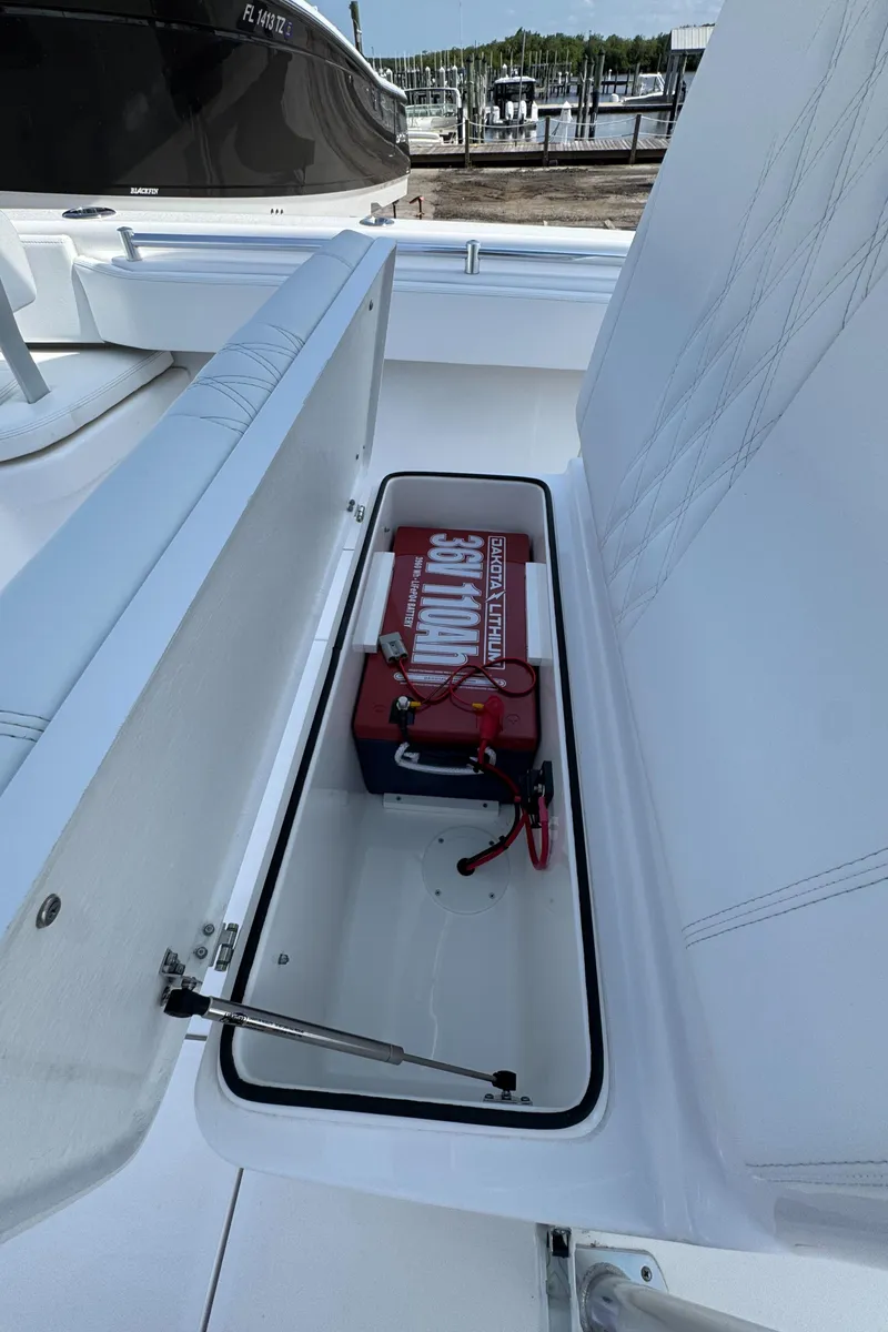 Slide: The Image of 2024 Contender 28 Tournament boat storage compartment with battery and wiring. - 13