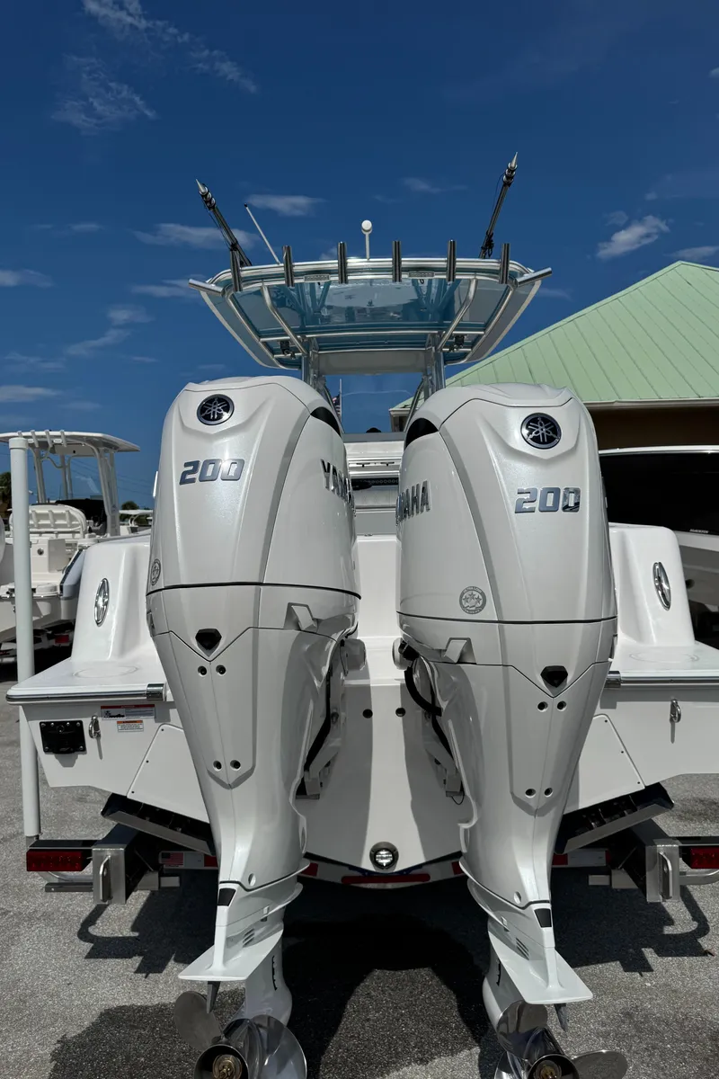 Slide: The Image of 2024 Contender 28 Tournament boat with dual Yamaha 200 engines, docked under clear blue sky. - 6