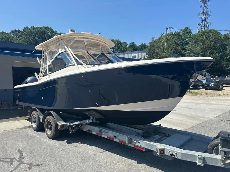 Slide: The Image of 2016 Grady-White Freedom 285 boat on trailer, parked outdoors under clear sky. - 1