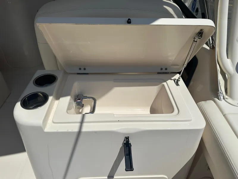 Slide: The Image of Open storage compartment on 2016 Grady-White Freedom 285 boat with cup holders. - 10