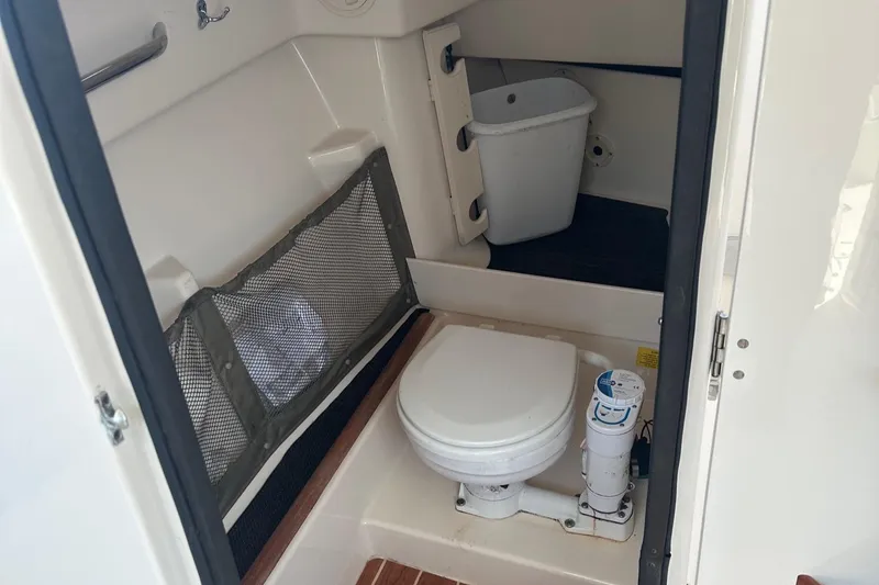 Slide: The Image of 2016 Grady-White Freedom 285 boat bathroom with toilet and storage. - 15
