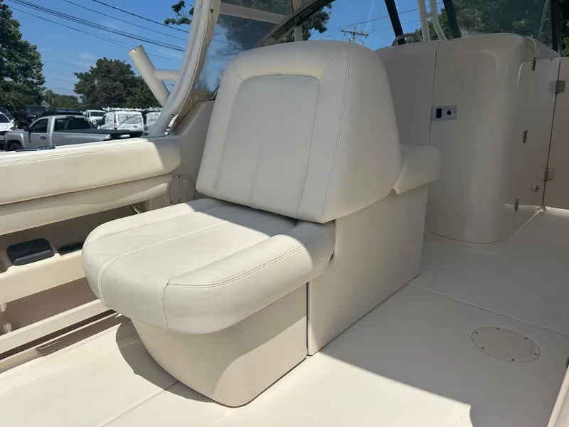 Slide: The Image of 2016 Grady-White Freedom 285 boat interior with white seating and console. - 7