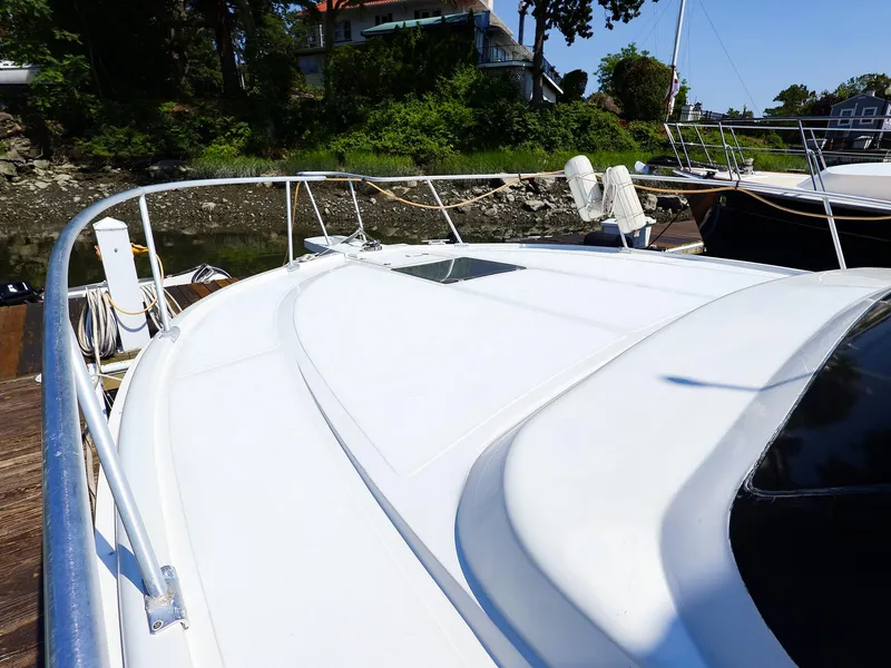 Slide: The Image of 1997 Luhrs 32 Convertible yacht docked, showcasing sleek white deck and railing. - 17