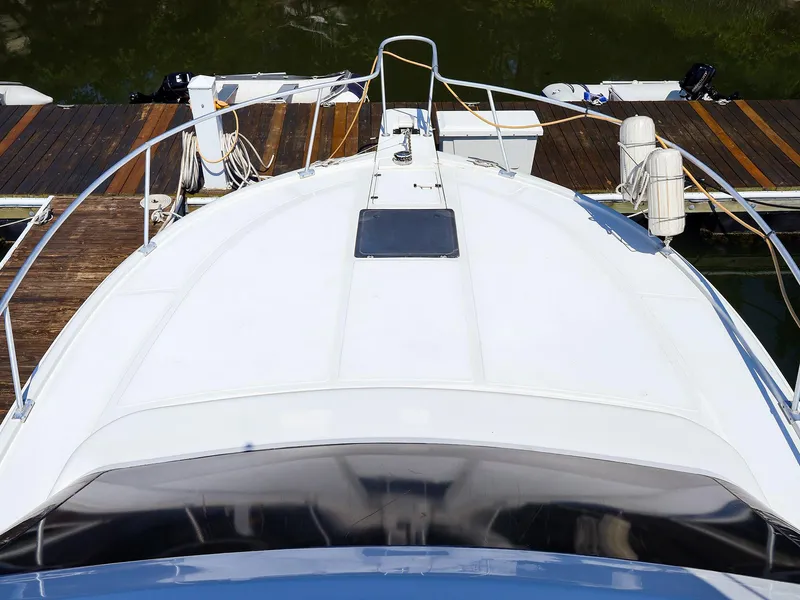 Slide: The Image of 1997 Luhrs 32 Convertible boat docked, viewed from above, showcasing deck and railing. - 2