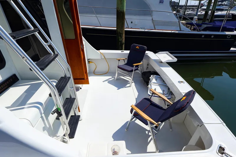 Slide: The Image of 1997 Luhrs 32 Convertible boat deck with chairs and ladder, docked at marina. - 20