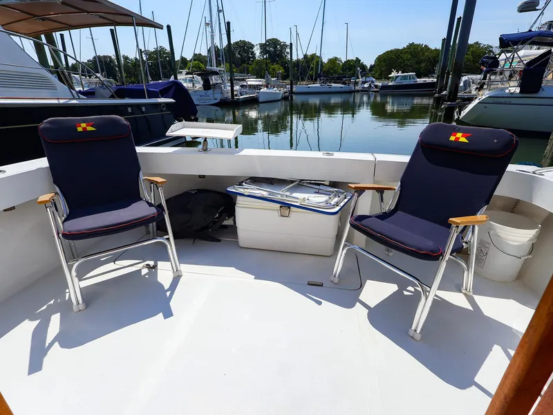 Slide: The Image of 1997 Luhrs 32 Convertible boat deck with chairs and cooler at marina. - 22