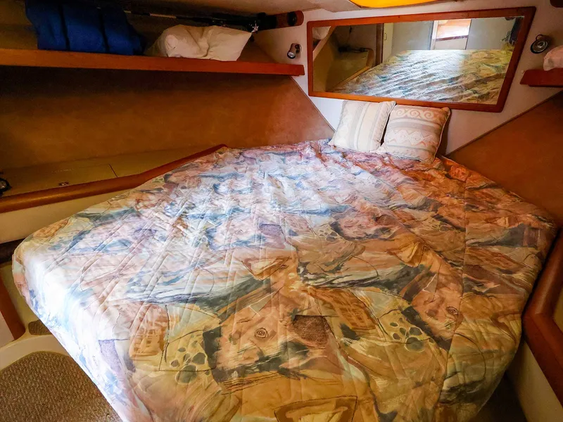 Slide: The Image of 1997 Luhrs 32 Convertible cabin with patterned bedding and mirror. - 26