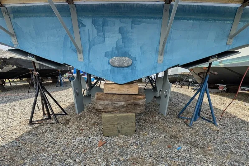 Slide: The Image of 1997 Luhrs 32 Convertible boat hull on stands, showing propellers and rudders. - 28