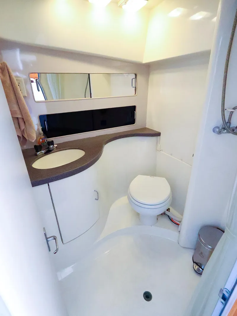 Slide: The Image of Bathroom interior of 1997 Luhrs 32 Convertible boat, featuring sink and toilet. - 30