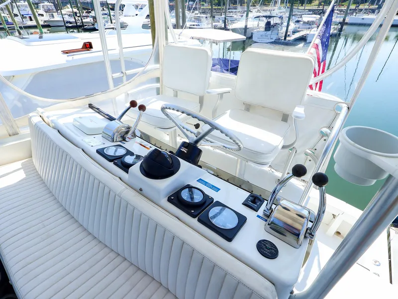 Slide: The Image of 1997 Luhrs 32 Convertible boat helm with steering wheel and controls, docked in marina. - 4