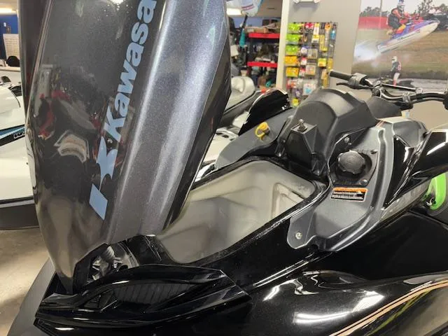 Slide: The Image of 2019 Kawasaki Ultra LX jet ski with open storage compartment in a showroom. - 13