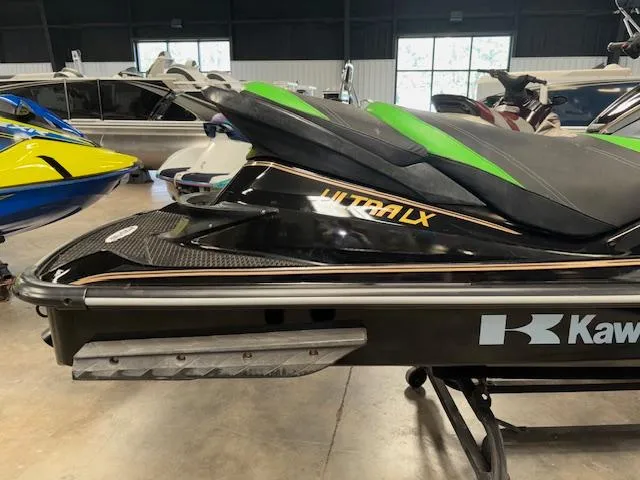 Slide: The Image of 2019 Kawasaki Ultra LX jet ski in showroom, featuring sleek black and green design. - 9