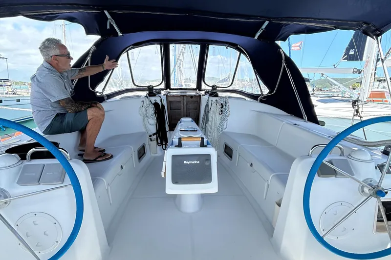 Slide: The Image of Man sitting in cockpit of 2007 Beneteau Cyclades 50.3 sailboat, showcasing interior features. - 2