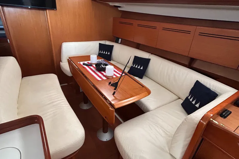 Slide: The Image of Interior of 2007 Beneteau Cyclades 50.3 yacht with cozy seating and wooden table. - 21