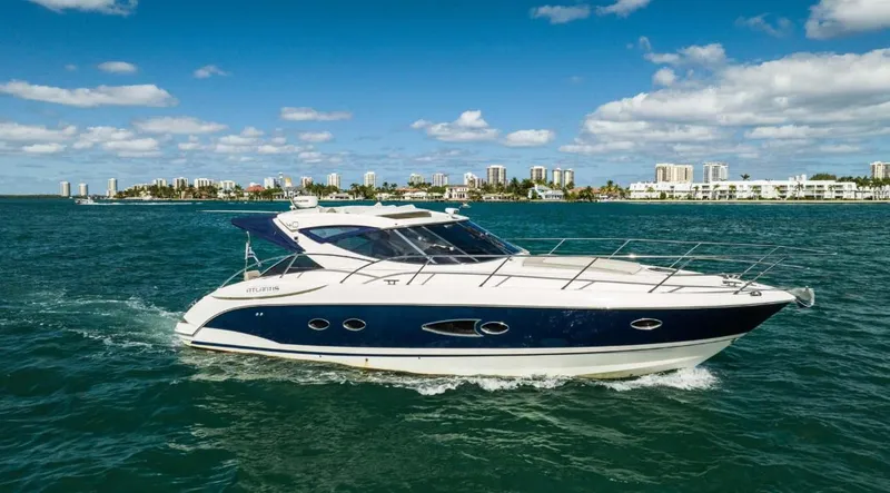 The Image of 2011 Azimut Atlantis 40 yacht cruising on blue ocean near city skyline. - 1