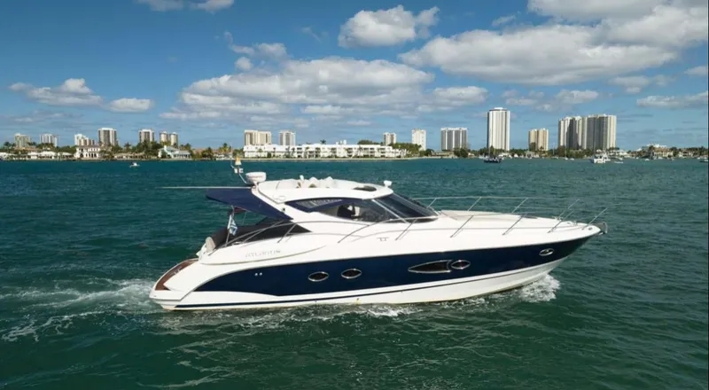 Slide: The Image of 2011 Azimut Atlantis 40 yacht cruising on a sunny day with city skyline backdrop. - 40