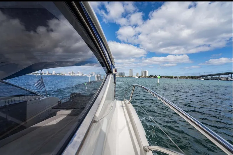 Slide: The Image of 2011 Azimut Atlantis 40 yacht cruising on a sunny day with city skyline in the background. - 7