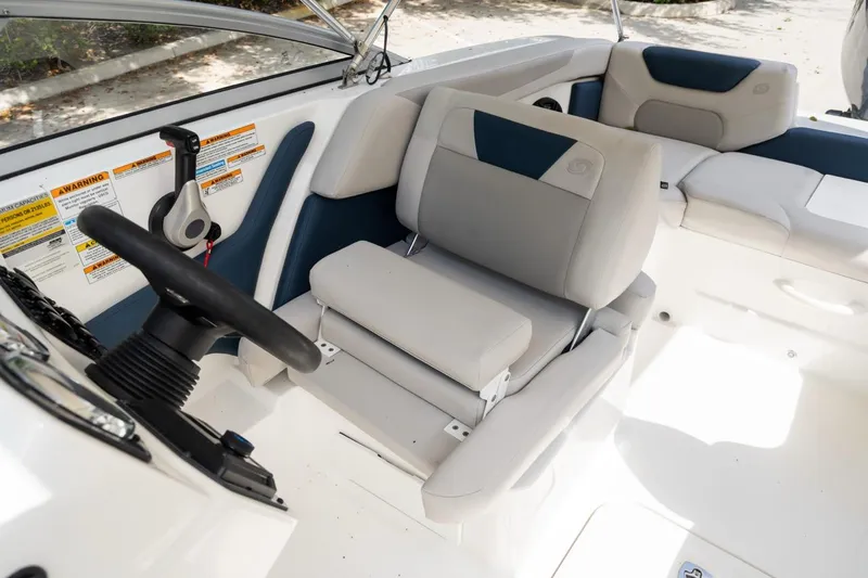 Slide: The Image of 2025 Hurricane SunDeck 2050 OB boat interior with steering wheel and cushioned seating. - 14