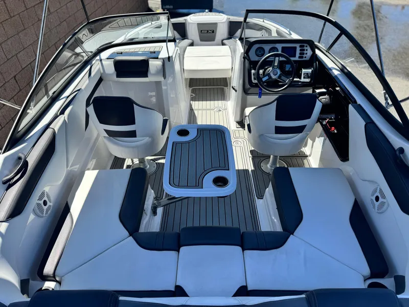 Slide: The Image of 2021 Yamaha Boats SX210 interior with seating, steering wheel, and table. - 12