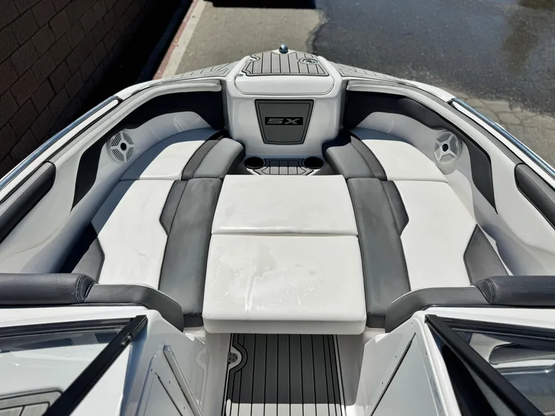 Slide: The Image of 2021 Yamaha Boats SX210 interior with cushioned seating and cup holders. - 13