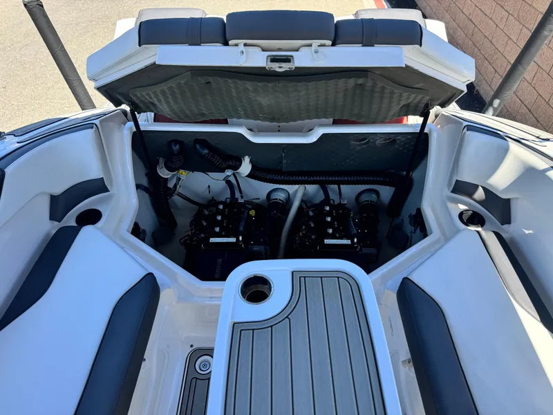 Slide: The Image of 2021 Yamaha Boats SX210 engine compartment with open hatch, showcasing dual engines and seating area. - 18