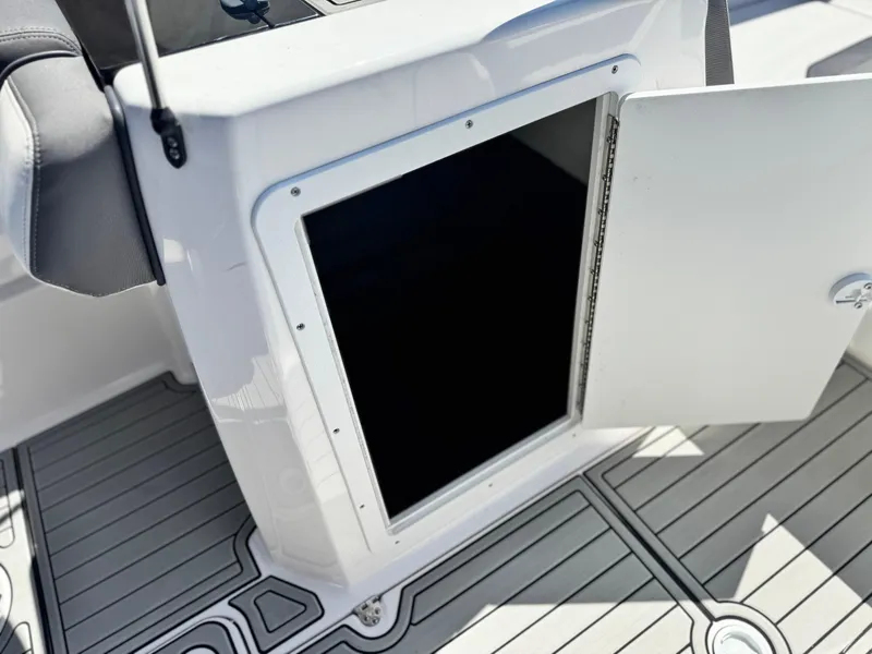 Slide: The Image of Open storage compartment on 2021 Yamaha SX210 boat, featuring sleek design and spacious interior. - 21