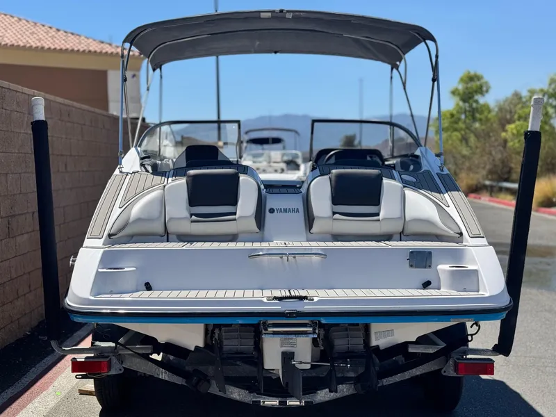 Slide: The Image of 2021 Yamaha SX210 boat with canopy, parked on trailer, rear view. - 4
