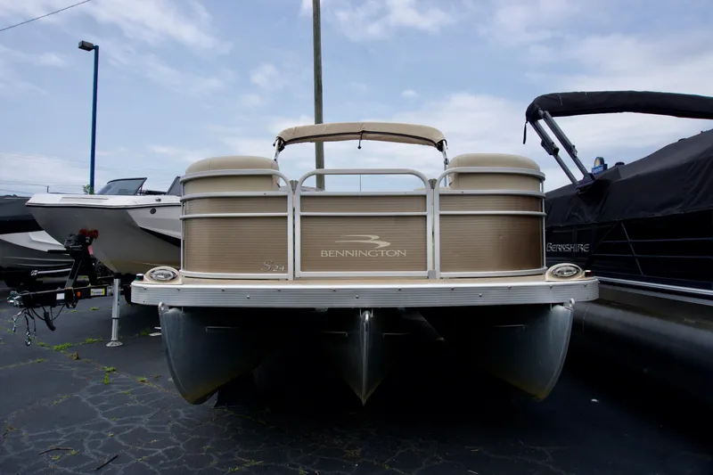 Slide: The Image of 2012 Bennington 24 SSL pontoon boat displayed in a marina setting. - 1