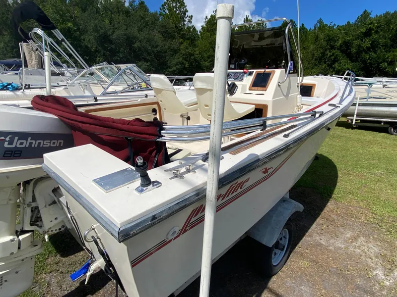 Slide: The Image of 1988 Pro-Line 17cc boat with Johnson 88 outboard motor, parked on grass. - 3