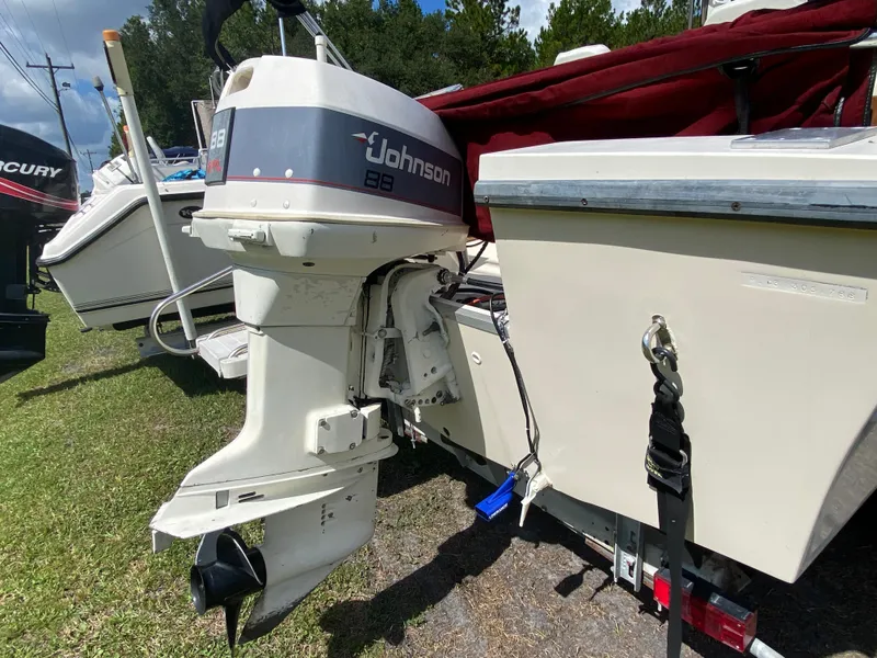 Slide: The Image of 1988 Pro-Line 17cc boat with Johnson 88 outboard motor, parked on grass. - 4