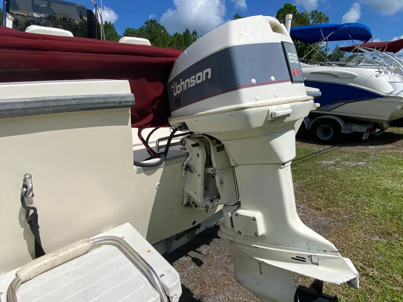 Slide: The Image of 1988 Pro-Line 17cc boat with Johnson 88 outboard motor, parked on grass. - 6