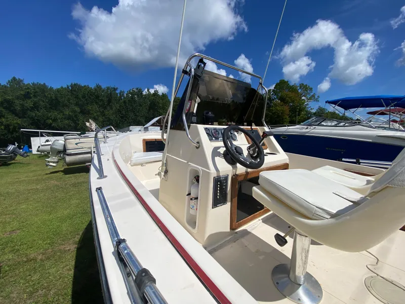 Slide: The Image of 1988 Pro-Line 17cc boat with steering console, white seating, and clear blue sky background. - 7