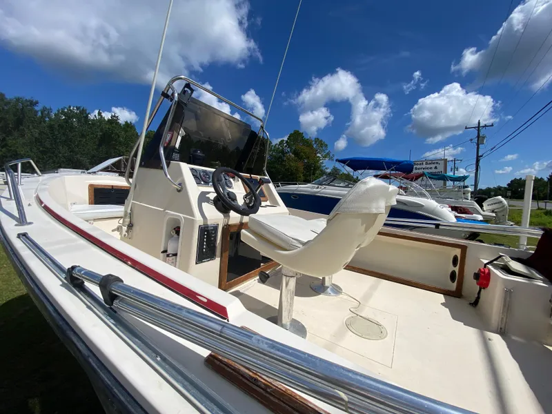 Slide: The Image of 1988 Pro-Line 17cc boat with steering console, white seating, and clear blue sky background. - 8